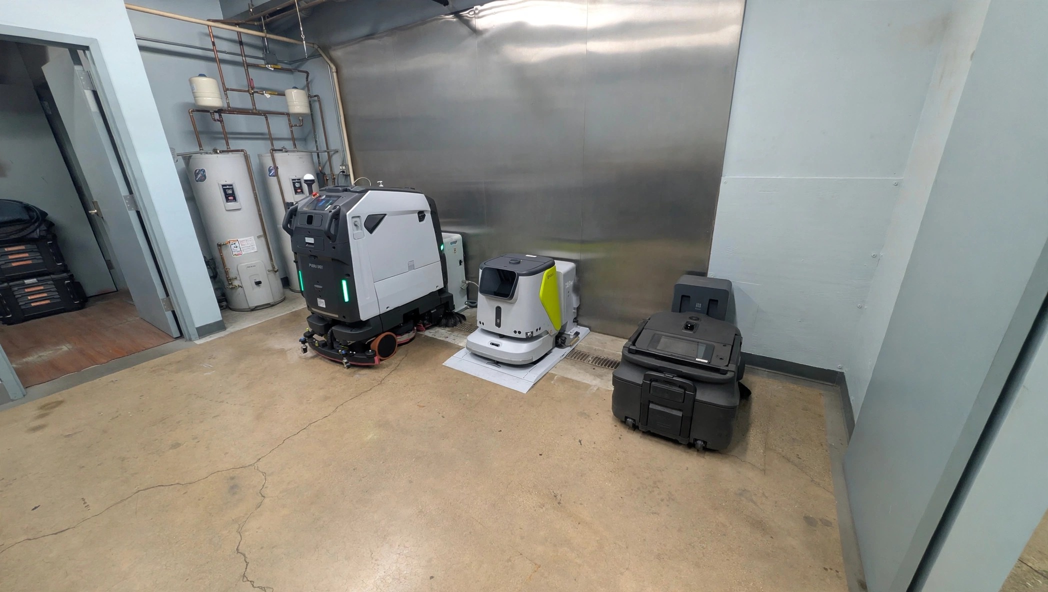 PUDU BG1 scrubber-dryer and other cleaning robots docked in the GotBots247 service bay in Wheeling, IL